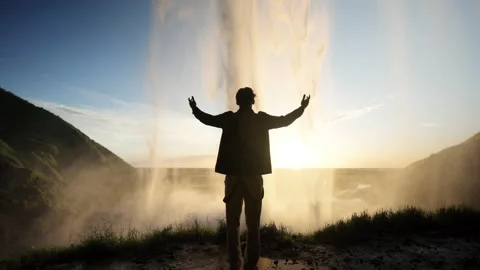 Back view of man raising his hands to the active geyser Strokkur, Iceland Stock Footage 253690894