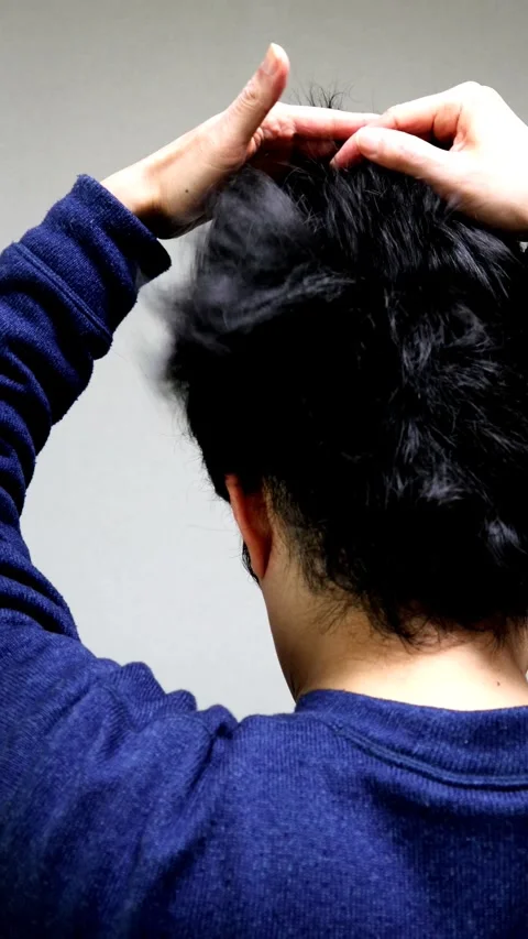 The back view of a man running his hand through his hair. Video stock 336233197