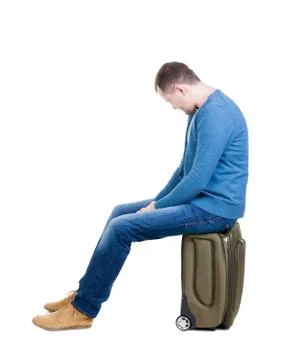 Back view of a man sitting on  suitcase Stock Photos