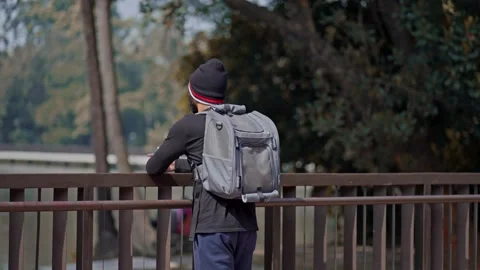 Back View of a Man Standing Alone in a Beautiful Green Park Video stock 298853301