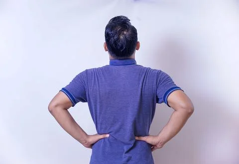 Back view of An man stands with hands on hips, showing confidence and conte.. Stock Photos