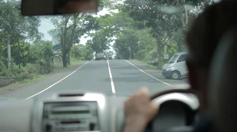 Back view of man with sunglasses driving a car on road with green trees Stock Footage 68030164