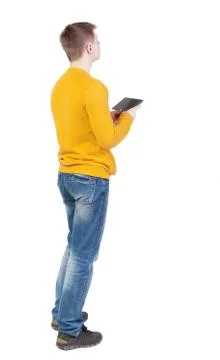 Back view of man with tablet. Standing young guy Stock Photos