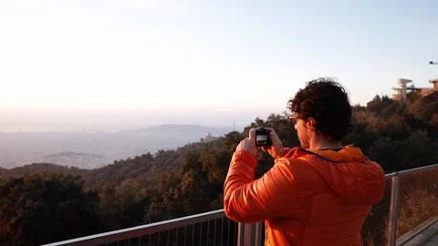 Back view of a man taking pictures at sunrise Stock Footage 104123565
