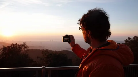 Back view of a man taking pictures at sunrise Stock Footage 104123566