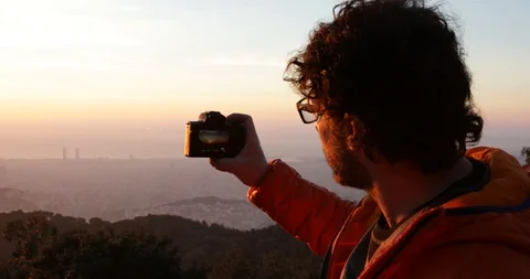 Back view of a man taking pictures at sunrise Stock Footage 104123637