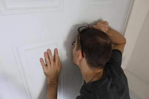 Back view man touching door with both hands home security concept 库存照片