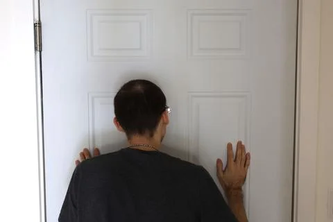 Back view man touching door with both hands home security concept Foto stock