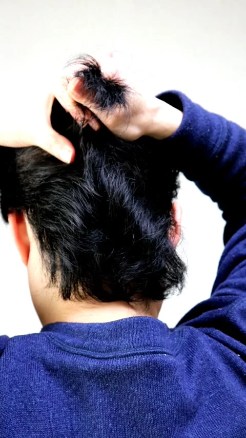 The back view of a man tying up his long hair. Stock Footage 336225136