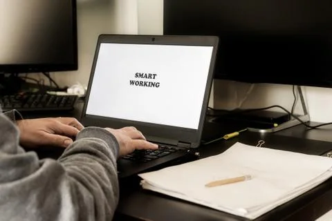 Back view of man using laptop for smart working from home. Stock Photos