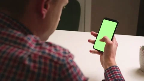 Back View. Man using phone with green screen chromakey, Surfing internet Stock Footage 146599585