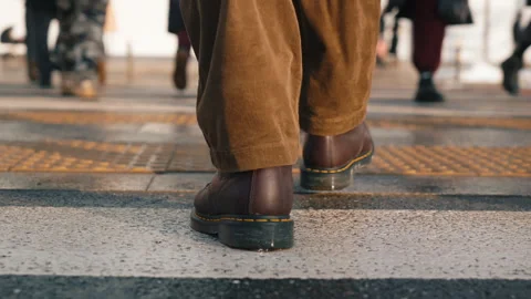 Back view man walking across city street crosswalk. Male feet steps close-up Vídeos de archivo 326826346