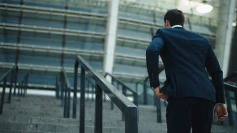 Back view man walking alone at city center. Businessman going upstairs at street Stock Footage 124695990