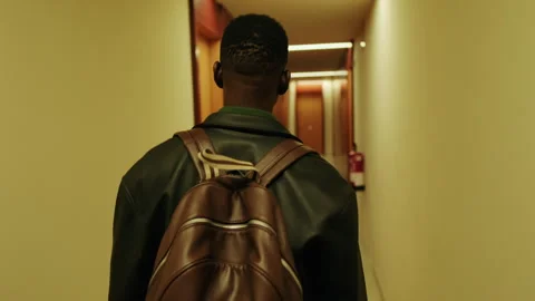 Back view of the Man Walking Down Hallway With Backpack Stock Footage 315396326