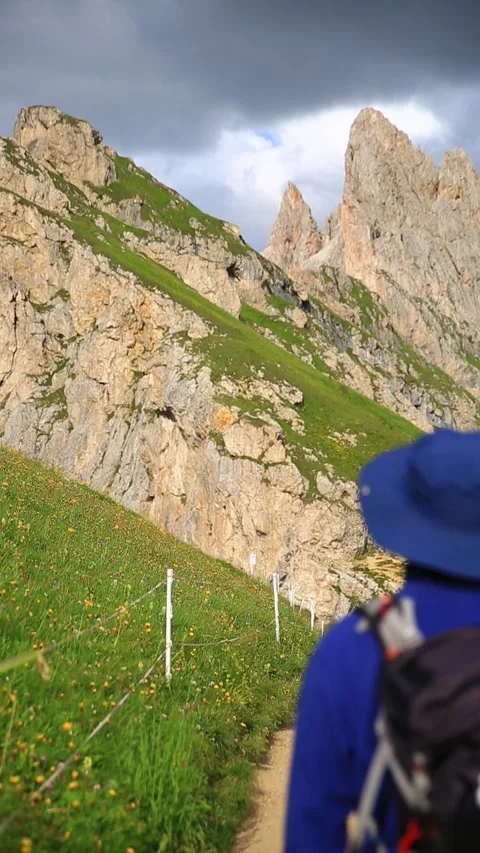Back view of a man walking to the mountain Seceda peak, Video stock 284463084