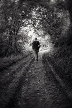 Back view of a man walking on a path through the forest. Foto stock