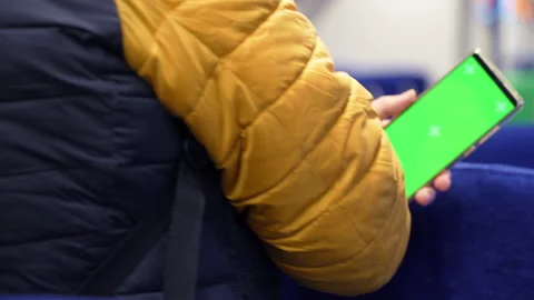 Back view of man watch smart phone with green screen and browsing online in Stock Footage 168543185