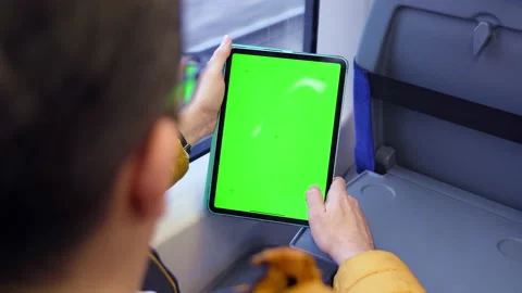 Back view of man watch tablet pc with green screen and browsing online in train. Stock Footage 168131495
