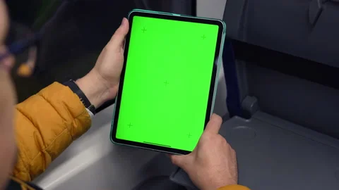 Back view of man watch tablet pc with green screen and browsing online in train Stock Footage 168232573