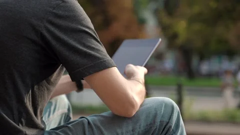 Back view of man wearing casual clothes, sitting , using tablet Stock Footage 186557340