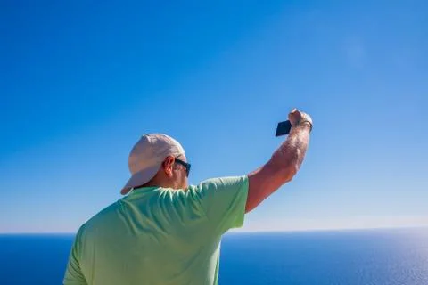 Back view of man web author is taking photo with cellphone camera for his web Stock Photos