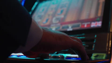 A back view of a man who plays slot machines in a casino. Long shutter speed Stock Footage 273034374