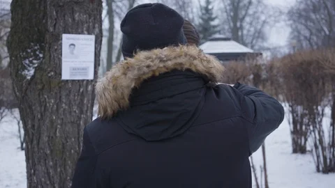Back view of man in winter clothes hugging desperate young Caucasian woman Stock Footage 123009684