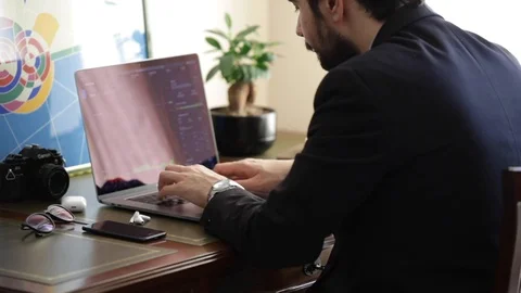 Back view of a man working from home at his laptop Stock Footage 129303256