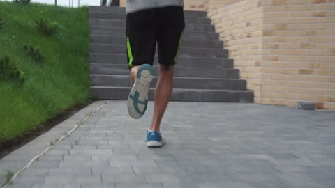 Back view of a man's feet running through the city 스톡 동영상 141073702