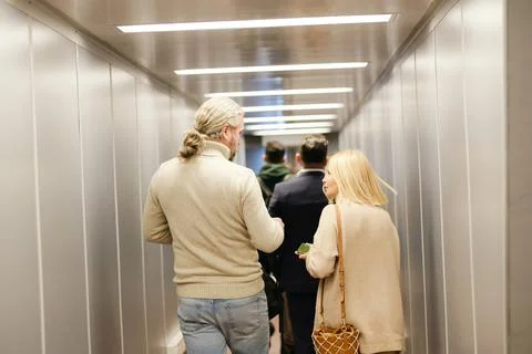 Back view of mature couple in casualwear, business traveler and young man with Stock Photos