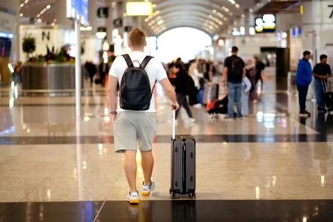 Back view of middle-aged caucasian blond man, wearing casual clothes holding Stock Photos