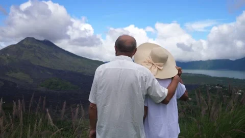Back view of the middle-aged couple enjoying the view of an island landscape of Stock Footage 151950630