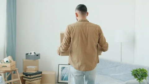 Back view of Middle Eastern man carrying cardboard boxes during relocation to Video stock 166028701