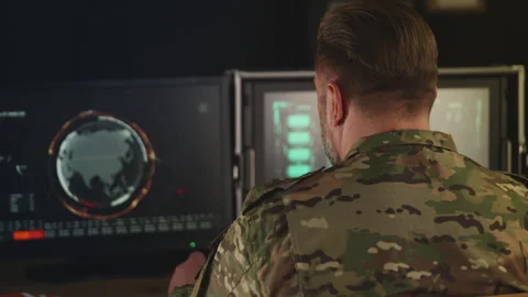 Back view of military officer working with satellite data in command hub Stock Footage 335537637