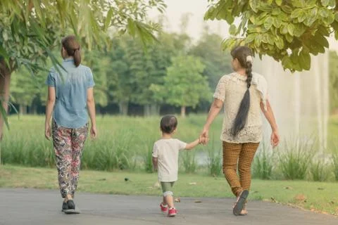 Back view of mom and son walk for excercise together before sunset in public  Stock Photos