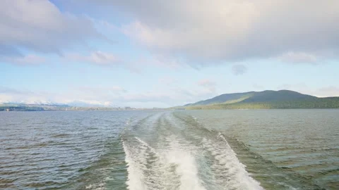 Back view of motor boat or ship leaving water trail as it sails in Te Anau Lake Stock Footage 289416729