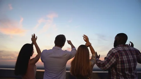 Back-view of multiracial friends dancing on roof top, corporative party, evening Vidéo 117216557