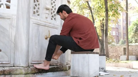 Back view of muslim bearded man performing ablution, man washing his feet Stock Footage 231088546