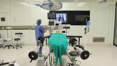 Back view of nurse switching on monitors in modular operating theatre. 스톡 동영상 129896360