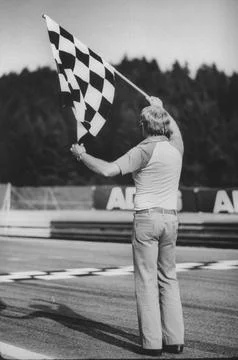 Back view of official as he waves checkered flag at Austrian Grand Prix finish l Stock Photos
