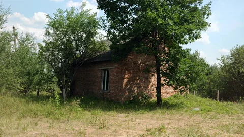Back view of an old abandoned red brick house in rural countryside Stock Footage 339588188