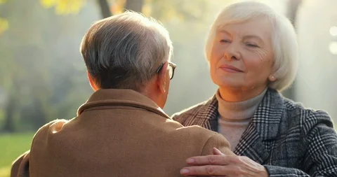 Back view on the old Caucasian man hugging his grey haired man in the autumn Stock Footage 101008310