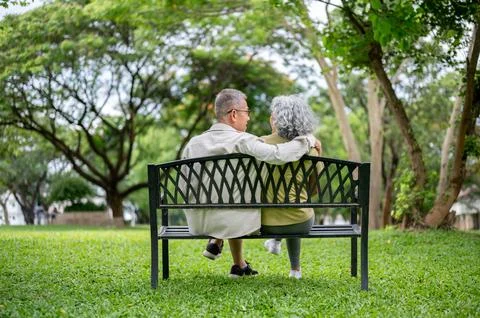 Back view of old man talking to woman and hugging shoulder while sitting to.. Stockfoto's