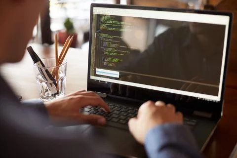 Back view over the shoulder shot of developer programmer with laptop. Program Stock Photos