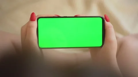 Back view over shoulder of young girl using smartphone with green screen sitting Stock Footage 141919621