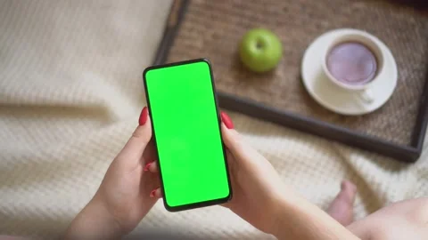 Back view over shoulder of young girl using smartphone with green screen sitting Stock Footage 141919684