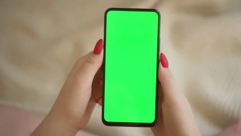 Back view over shoulder of young girl using smartphone with green screen sitting Stock Footage 141994516