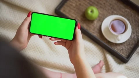 Back view over shoulder of young girl using smartphone with green screen sitting Stock Footage 142139948