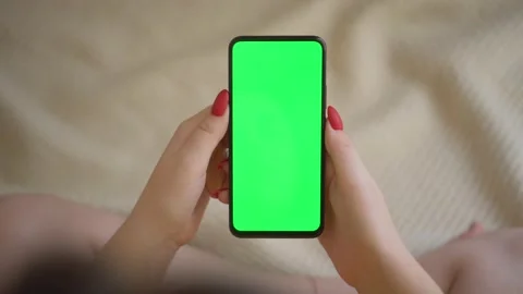 Back view over shoulder of young girl using smartphone with green screen sitting Stock Footage 142337377