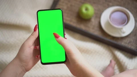 Back view over shoulder of young girl using smartphone with green screen sitting Stock Footage 142340087